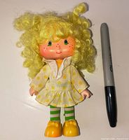 Front view of Lemon Meringue doll beside Sharpie for scale