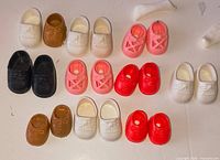All twelve pairs of Strawberry Shortcake shoes laid out by colour and style