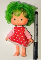 Front view of 1982 Strawberry Shortcake doll beside Sharpie for scale