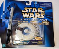 Front view of sealed Star Wars Episode I die-cast Trade Federation Battleship on blister card with Sharpie for scale (marker not included)