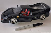 Left front side view with doors open, interior and engine detail visible, size reference pen shown