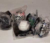 Five sealed mini goalie helmets in bags