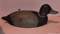 Full left side view of carved wooden duck decoy