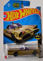 Front view of sealed gold Batmobile on Hot Wheels card showing artwork and car