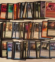 Spread of roughly 100 assorted Magic: The Gathering cards showing variety of colors and card types