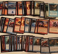 Spread of roughly 100 Magic cards assorted colors and sets