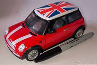 Top and side view of red Mini Cooper S diecast model car beside marker for scale