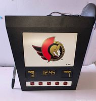 Front view showing Ottawa Senators logo and printed scoreboard graphics, Sharpie marker for scale