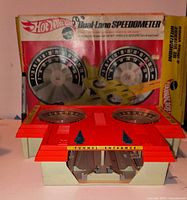 Dual-Lane Speedometer accessory placed in front of box