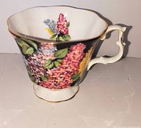 Right side view of bone china teacup showing floral design and branch handle