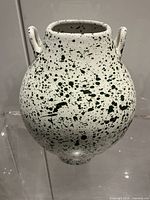 Front view of white ceramic splatter vase showing handles and overall pattern