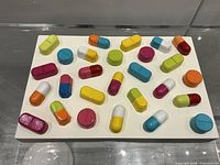 Front view of rectangular base with colourful pill forms
