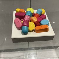 Top view of multicolour pill sculpture on white base
