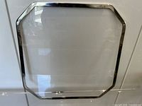 Single placemat front view showing clear acrylic center and chrome frame