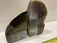 Pair of geode bookends standing upright against white background with tape measure showing size