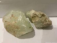 Two pale green stone specimens side by side