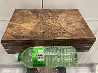 Top view of carved teak box with water bottle for scale