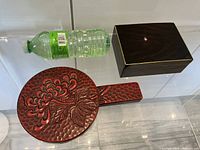 Top view of red carved lacquer mirror, dark lacquer box and scale bottle