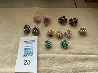All eight pairs of beaded clip-on earrings displayed on cloth background