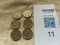 Six UK £1 coins reverse sides showing floral emblem design