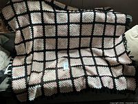 Full view of crocheted throw draped on sofa