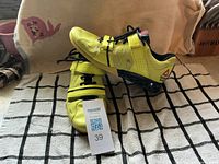 Left and right yellow Reebok Crossfit shoes size 9 showing uppers and strap