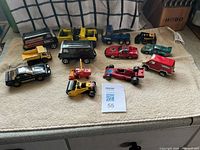 All twelve die-cast vehicles arrayed on towel