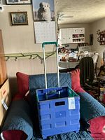 Cart standing open on chair showing crate body and extended handle