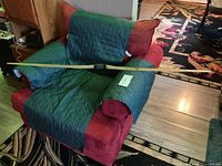 Full view of longbow laid across chair showing overall length and limb color