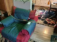 Full view of wooden longbow on chair, string attached