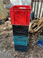 Stack of four plastic milk crates in varied colours