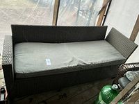 Front view of grey synthetic-rattan couch with cushion