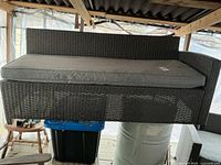 Full view of rattan couch lounger with cushion