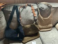Front view of all three crocheted handbags on sofa