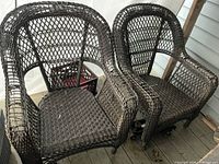 Front view of two brown wicker armchairs showing overall design and condition