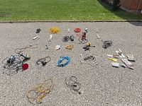 Lot overview showing cords, work lights, power strip and hand tools spread on pavement