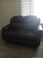 Front view of dark brown bonded leather reclining loveseat
