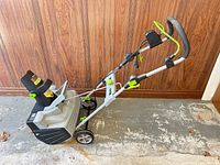 Side view showing full snow thrower, wheels, handle, chute