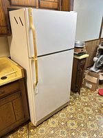 Front and left side view of GE white top-freezer refrigerator