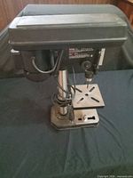 Full view of Jobmate drill press showing base, column, motor housing and table