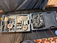 Both open cases showing angle grinder, die grinder, discs, accessories