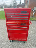 Front view of red Mastercraft rolling tool chest showing drawers, casters, side handle