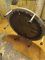 Underside view of trampoline showing metal frame and detachable legs