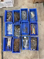 Twelve blue bins filled with mixed fasteners and small tools