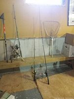 Wide view showing four rods with reels and landing net