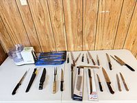 Entire lot laid out on table: knives, forks, honing steel, roll and food processor