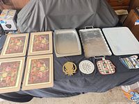 Full lot: four placemats, three trays, brass trivet, doily, potholder, oven mitt