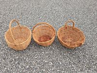 Front view of three round wicker baskets with handles