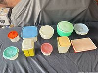 Ten Tupperware containers arranged on table, front and back rows visible