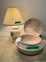 Lamp with shade alongside two stone bowls